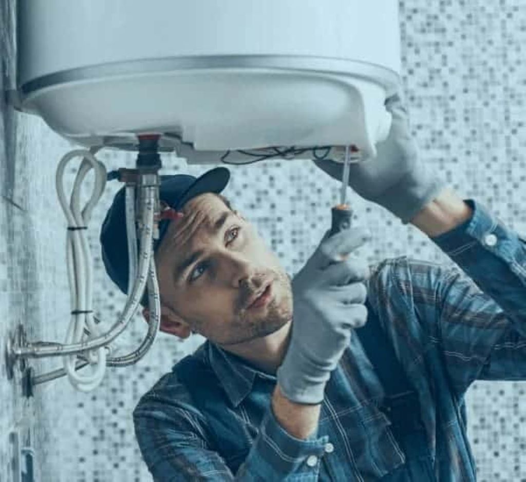 Person shivering in a cold London home with a broken boiler, highlighting fast repair services from top local experts