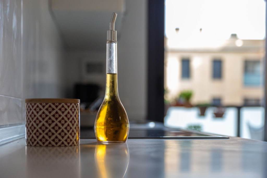 Assorted cooking oils displayed neatly in a small urban kitchen setting