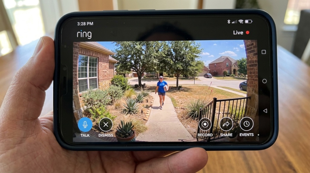 Smartphone displaying Ring camera live view of a Texas front yard.